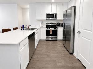 a kitchen with white cabinets and a stainless steel refrigerator at 3BR Near Gruene Historic District, Comal, and Guadalupe Rivers & Schlitterbahn in New Braunfels