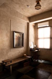 a room with a bench and a mirror on the wall at sishi hostel 巳時旅宿 in Tainan