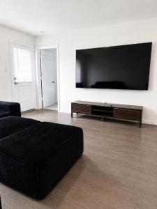 a living room with a black couch and a flat screen tv at 3BR Near Gruene Historic District, Comal, and Guadalupe Rivers & Schlitterbahn in New Braunfels