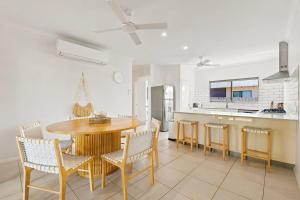 a kitchen and dining room with a wooden table and chairs at The Beachwood Nest in Broome