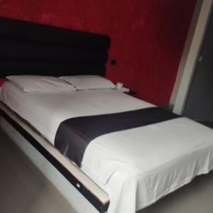 a bed in a room with a red wall at DLUXO hotel in Lima