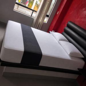 a bed with a black and white blanket on it at DLUXO hotel in Lima