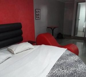 a bedroom with a white bed and a red chair at DLUXO hotel in Lima