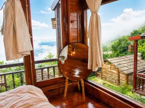 a bedroom with a bed and a large window at Mống Vàng Retreat Tà Xùa in Sơn La