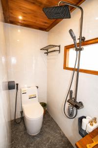 a bathroom with a toilet and a shower at Mống Vàng Retreat Tà Xùa in Sơn La