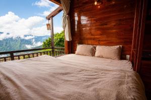 a bed in a room with a view of the mountains at Mống Vàng Retreat Tà Xùa in Sơn La