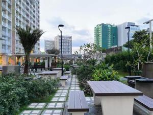 a row of benches in a park with buildings at Infina Towers in Manila