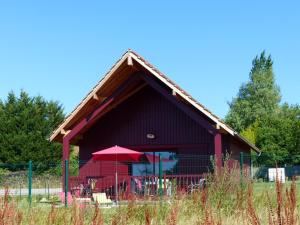 a red barn with a red umbrella in a field at Gîte cozy avec terrasse et climatisation près de Saint Pourçain - FR-1-489-267 in Meillard