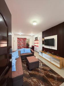 a living room with a couch and a tv at Casa Saturnino Private Staycation 
