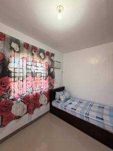 a bedroom with a bed and a wall with roses at Casa Saturnino Private Staycation 