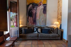 a couch in a living room with a painting on the wall at Mezquida del puerto in Jávea