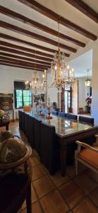 a kitchen with a large island in a room with chandeliers at Mezquida del puerto in Jávea
