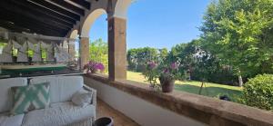 a couch on a porch with a view of a yard at Mezquida del puerto in Jávea