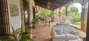 a porch with a couch and a table and chairs at Mezquida del puerto in Jávea