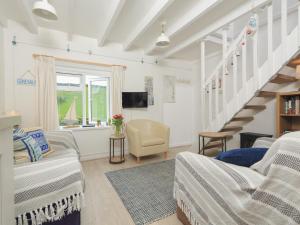 a living room with white furniture and a staircase at 4 Thornlea Mews in Kingsbridge
