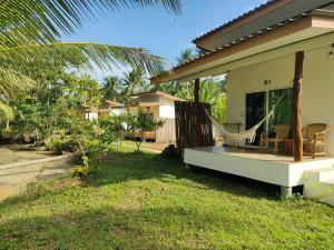 a porch of a house with a hammock on it at Suanthara kokut in Ko Kood