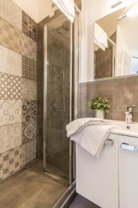 ローマにあるSantonofrio Apartmentsのバスルーム(シャワー、シンク、鏡付)