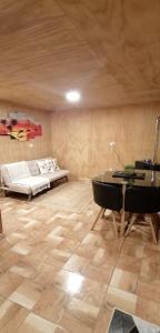 a room with a bed and a table and a piano at Departamento Tepual in Llanquihue