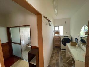 a bathroom with a sink and a washing machine at Shika Lodge Izu in Ito