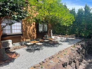 a patio with tables and chairs in front of a building at Shika Lodge Izu in Ito