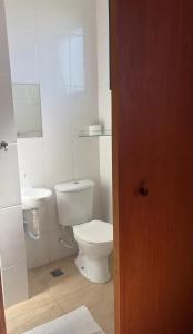 a white bathroom with a toilet and a sink at Hotel Flamboyant Taubate in Taubaté +49 photos