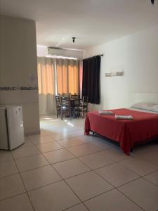 a bedroom with a bed and a table and chairs at Hotel Flamboyant Taubate in Taubaté