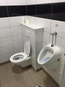 a bathroom with a toilet and a urinal at Rooms Prišlin in Bjelovar