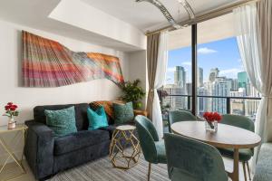a living room with a couch and a table at Miami Luxe Sky 27 Skyline View Stunning Water & City Lights View, Resort Pool,Gym,Spa Restaurants in Miami
