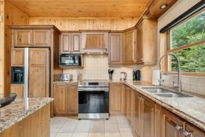 a kitchen with wooden cabinets and a stove top oven at Fiddler Lake Resort - Deer 87 in Mille-Isles