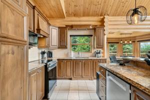 a kitchen with wooden cabinets and a wooden ceiling at Fiddler Lake Resort - Deer 87 in Mille-Isles