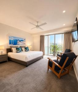 a bedroom with a bed and a television and a chair at Space Holiday Apartments in Maroochydore +62 photos