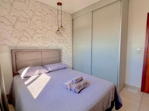 a bedroom with a bed with two pillows on it at Apê confortável com garagem e espaço de trabalho in Cuiabá +9 photos