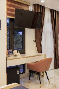 a desk with a television and a chair in a room at Sunrise Hotel Phước Kim in Bạc Liêu