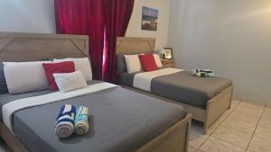 two beds with flip flops on them in a bedroom at La Villas at Pos Chiquito Caribbean Paradise in Aruba in Savaneta +39 photos