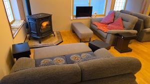 a living room with a couch and a wood stove at Komatsuya Seki Onsen in Myoko