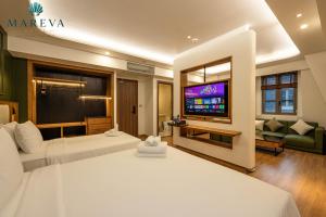 a hotel room with two beds and a flat screen tv at MAREVA KHEM BEACH HOTEL - Free Beach Shuttle in Phú Quốc