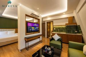a hotel room with a bed and a tv at MAREVA KHEM BEACH HOTEL - Free Beach Shuttle in Phú Quốc
