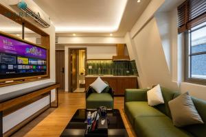 a living room with a couch and a flat screen tv at MAREVA KHEM BEACH HOTEL - Free Beach Shuttle in Phú Quốc