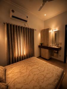 a bedroom with a bed and a dresser and a window at The Golden Window Villa in Amritsar