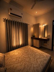 a bedroom with a bed and a dresser and a window at The Golden Window Villa in Amritsar +40 photos