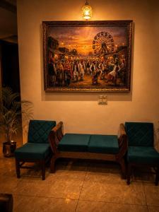 a waiting room with two chairs and a painting on the wall at The Golden Window Villa in Amritsar