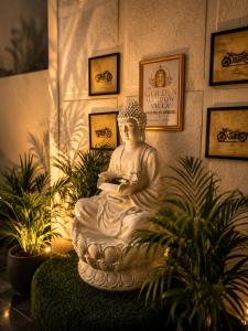 a statue sitting in a room with some plants at The Golden Window Villa in Amritsar