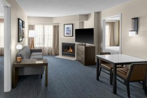 a hotel room with a living room with a fireplace at Residence Inn Mystic Groton in Mystic