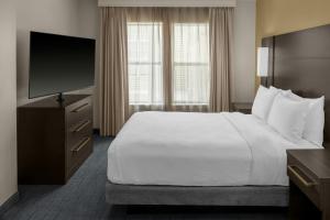 a hotel room with a bed and a flat screen tv at Residence Inn Mystic Groton in Mystic