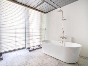 a white bath tub in a bathroom with a window at 제주 디스피어 호텔 D-Sphere in Jeju