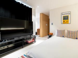a bedroom with a large television and a bed at 제주 디스피어 호텔 D-Sphere in Jeju