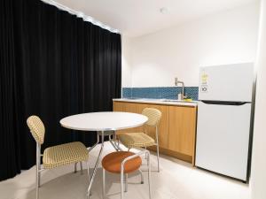 a kitchen with a table and chairs and a refrigerator at 제주 디스피어 호텔 D-Sphere in Jeju