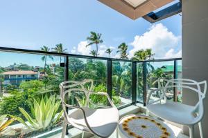 a balcony with chairs and a view of the ocean at Beachfront flat at Porto de Galinhas beach, close to the natural pools. in Porto De Galinhas