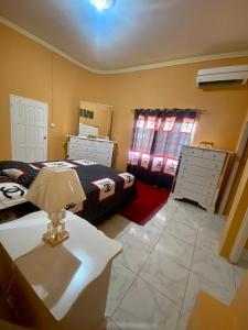 a bedroom with a bed and two dressers and a table at Vista Oceanica in Ocho Rios +48 photos