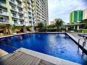a large blue swimming pool in the middle of a building at Infina Towers in Manila